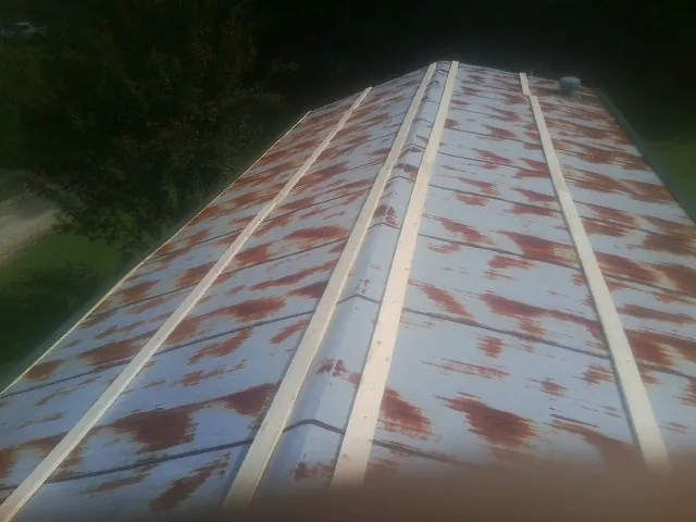 Rusted metal roof panels with new wood purlins before replacement — Storm Damage Roof Repair in Enville by Roofing Brothers