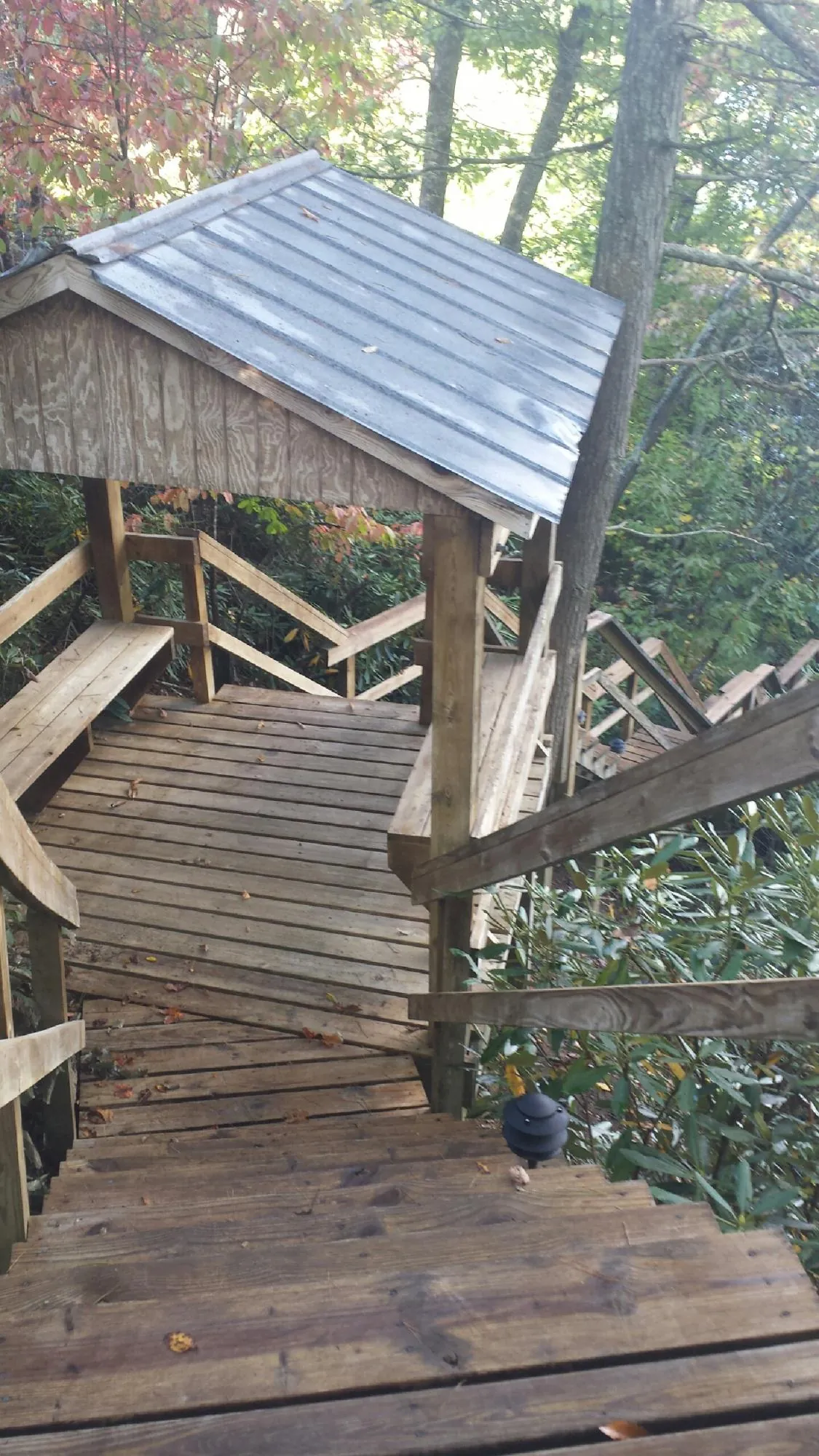 Metal roofed shelter over wooden steps on a wooded walkway — Skylight Repair & Installation work by our crew in Enville