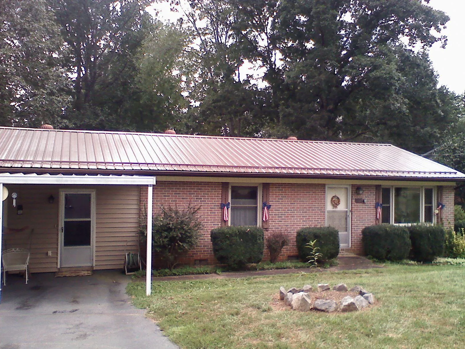 Bronze metal roof and carport on a brick ranch home — Roof Repair work by our crew in Enville